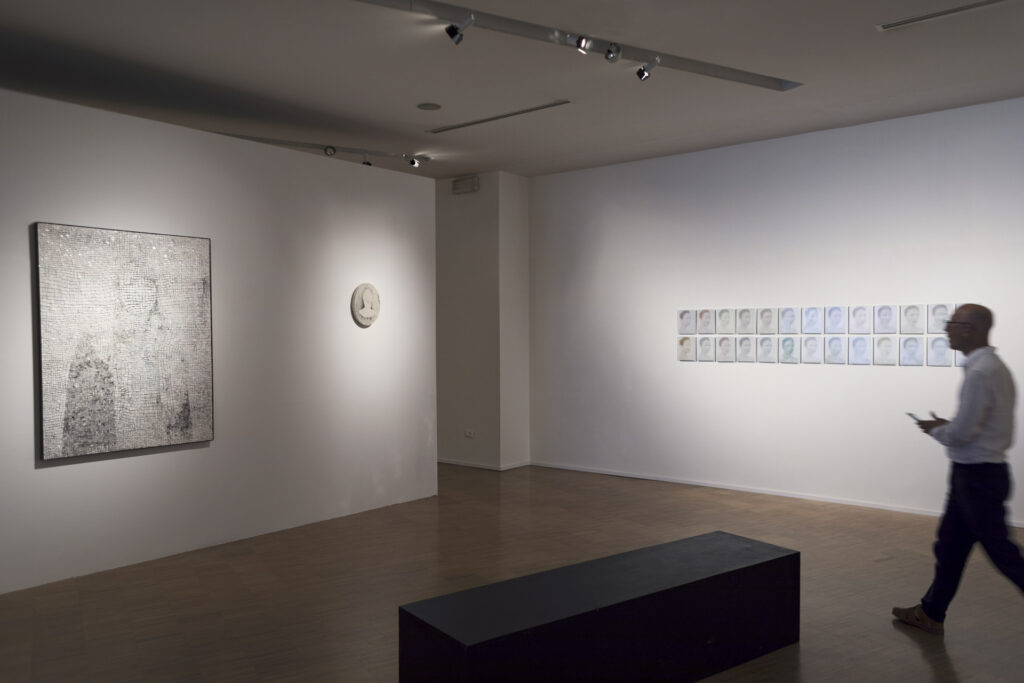 Michel Poivert walking through the exhibition Échos des visages by Clément Mitéran and Laurent Lafolie at the Lercaro Foundation in Bologna.